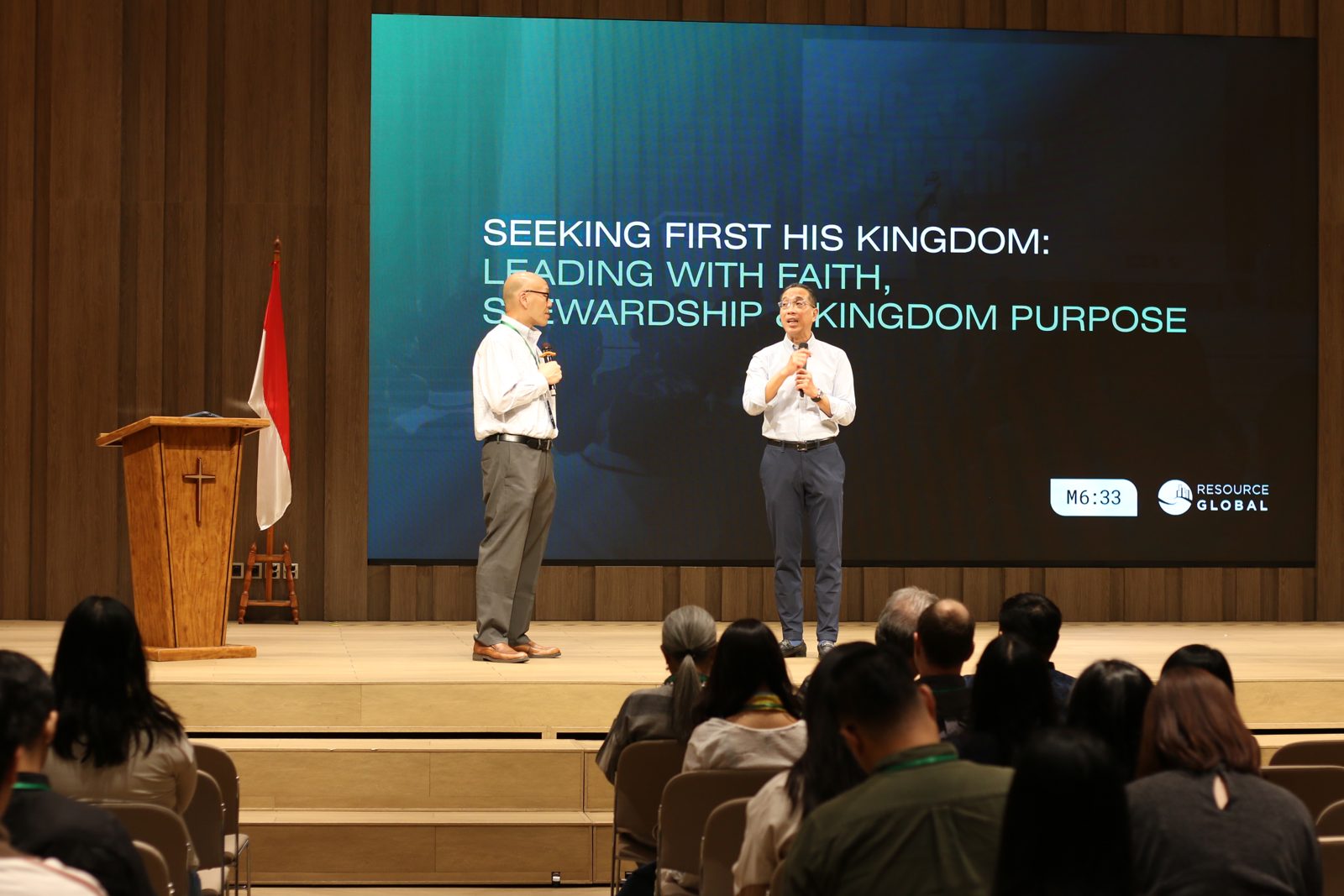 Two leaders on stage under the conference theme