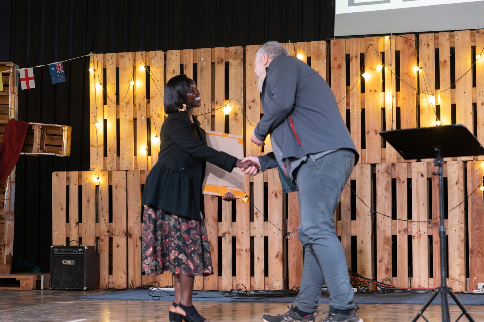 A graduate being congratulated on stage