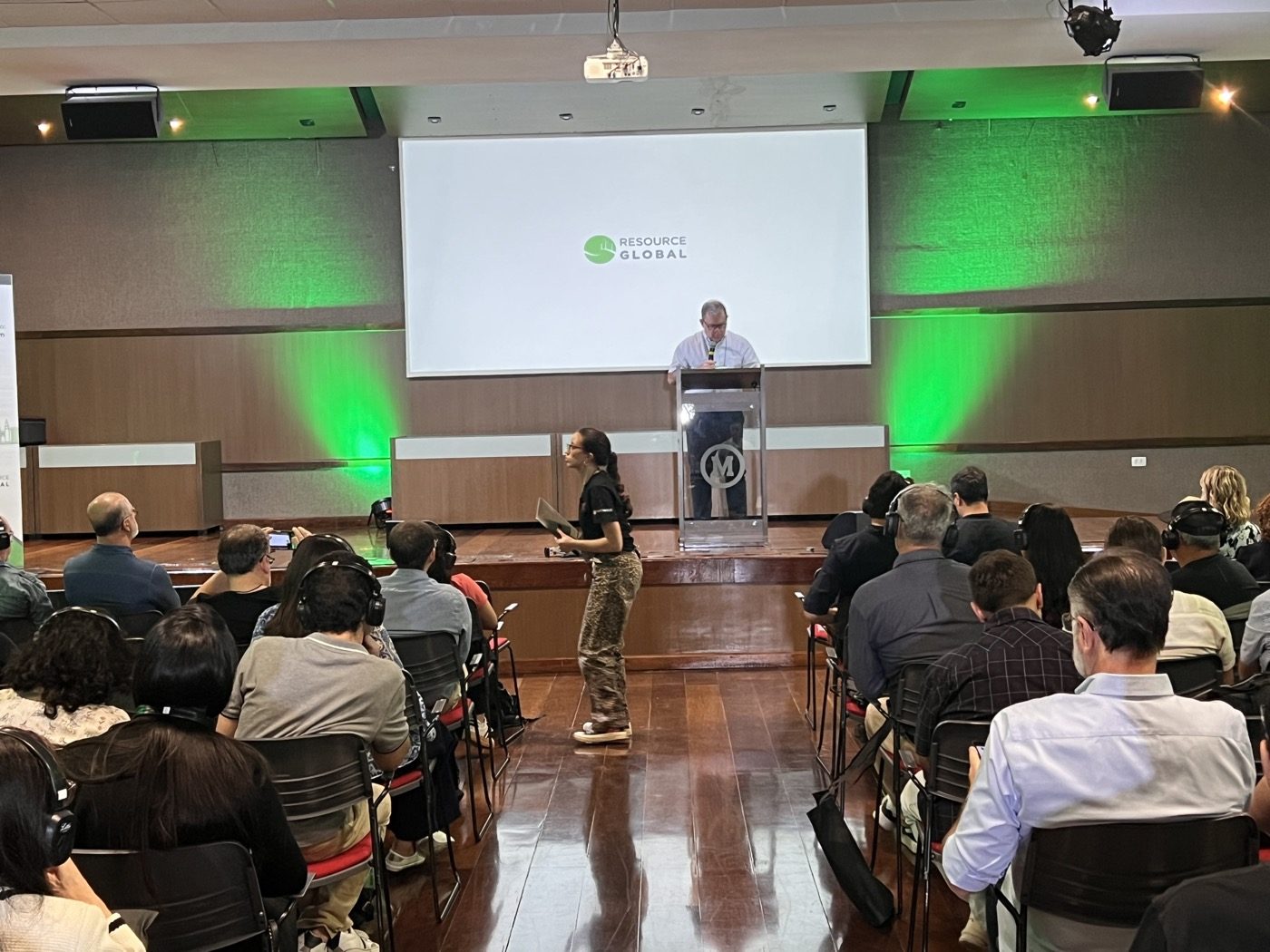 The conference hall in São Paulo with guests seated and a speaker on stage