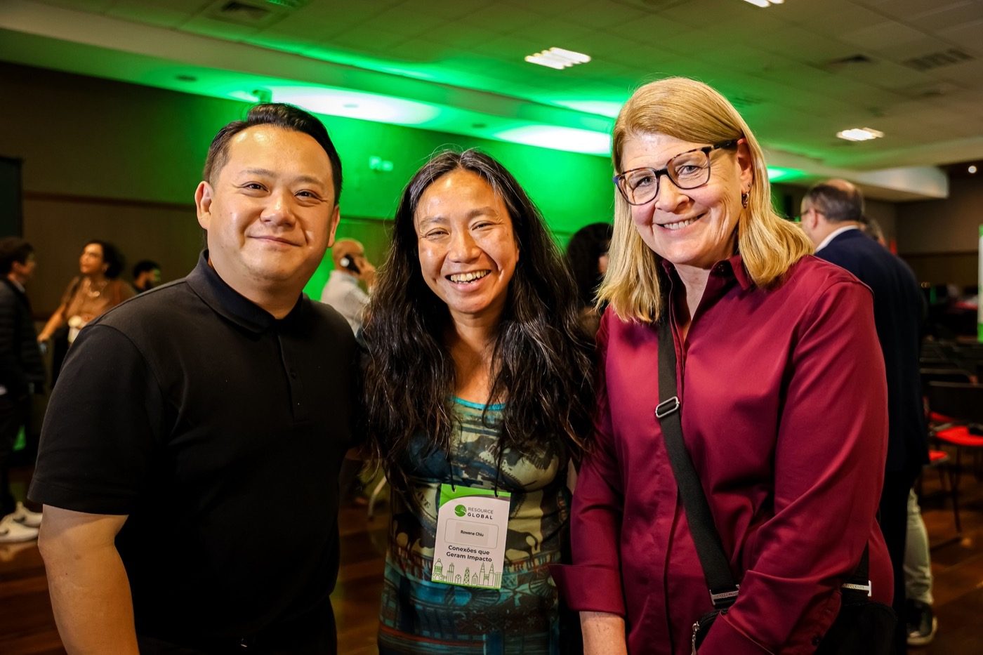 Three friends smiling together at the conference