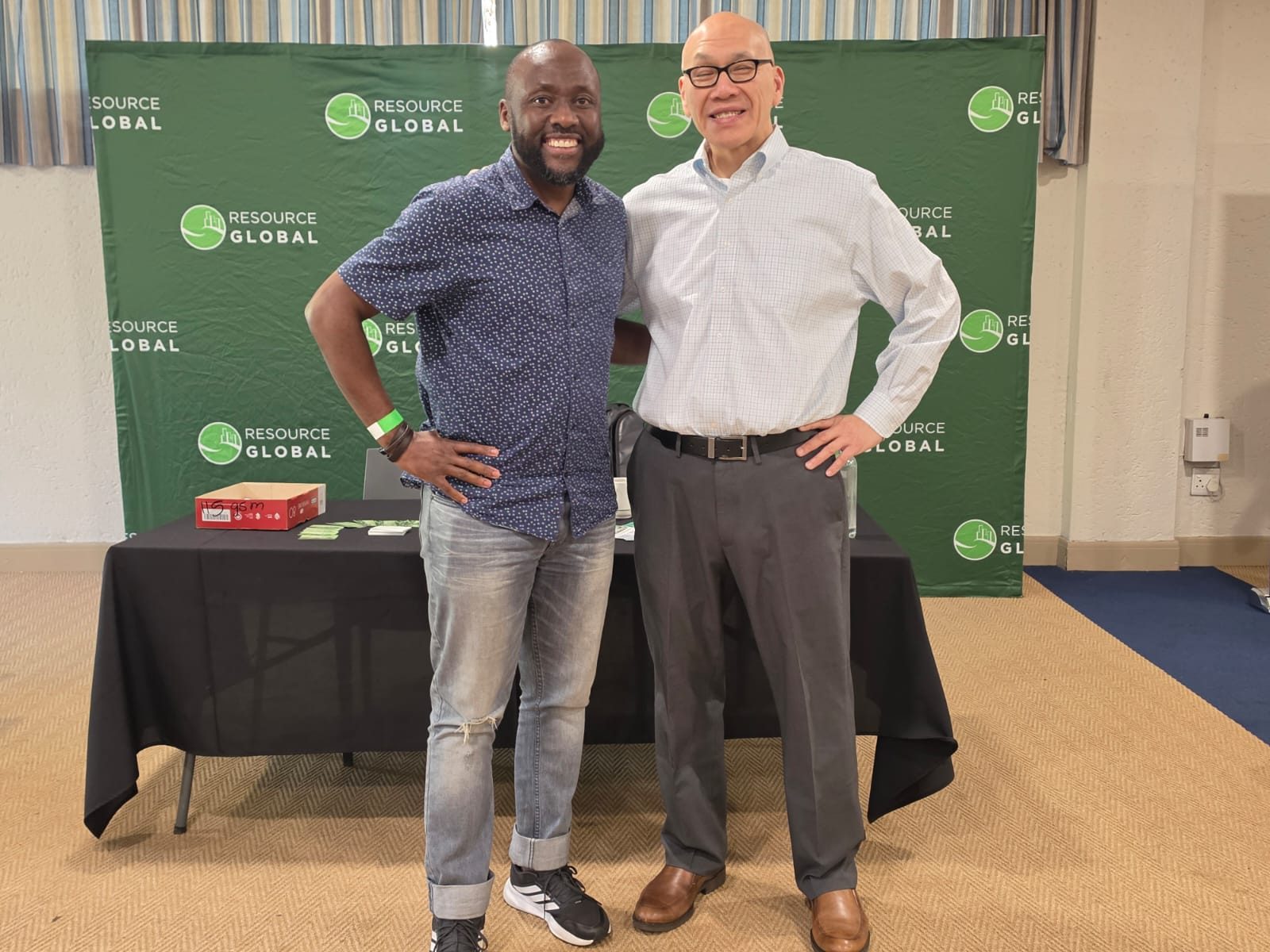 Two friends at the Resource Global backdrop